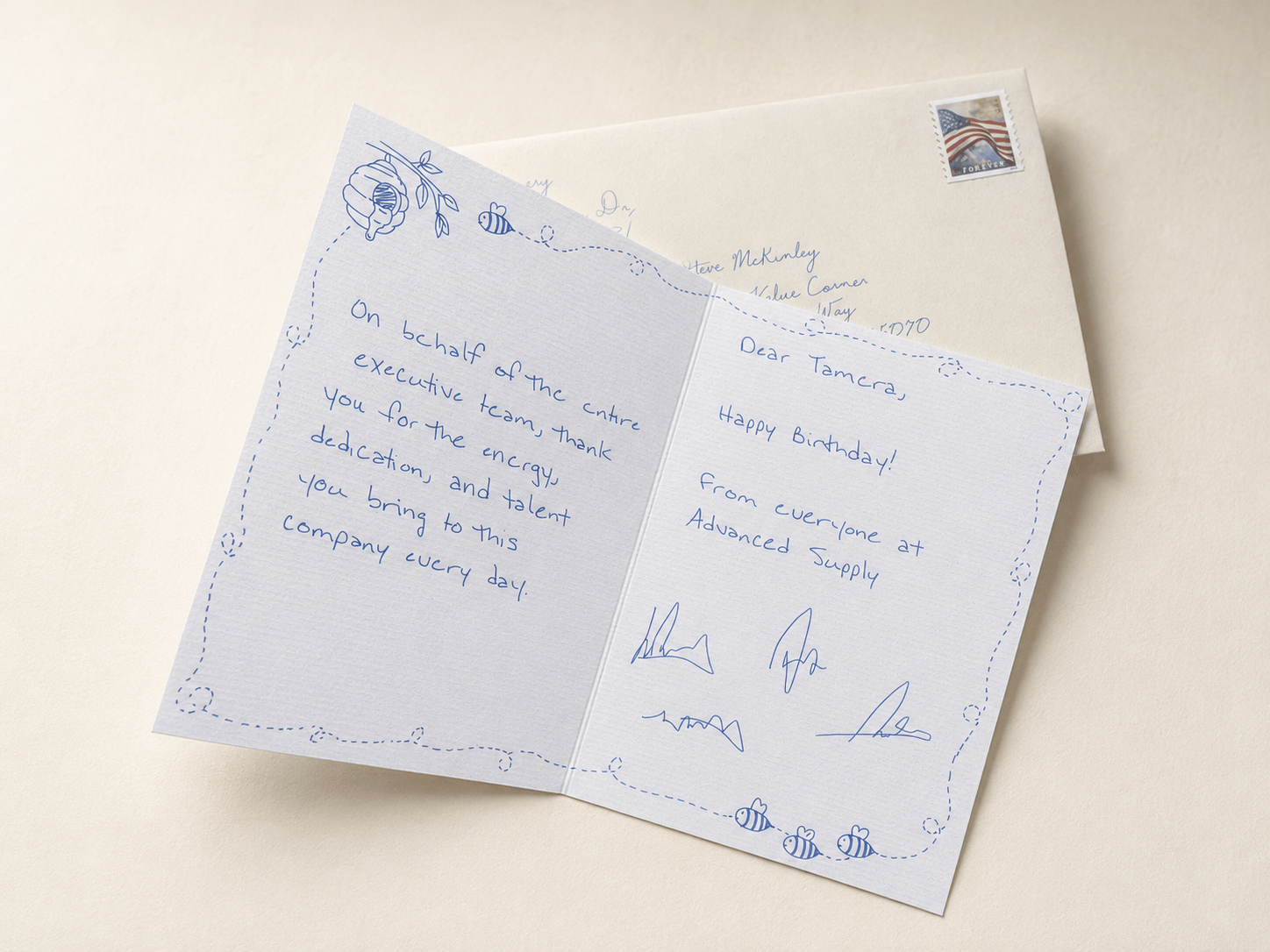 A client thank-you card written in blue ink beside its hand-addressed, stamped envelope